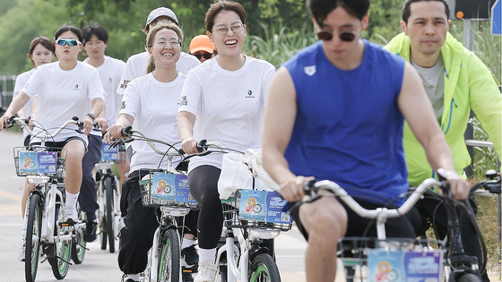 Participants in the 1st My PACE Hangang Triathlon Festival ride bicycles along the Han River on June 1, 2024. [NEWS1]