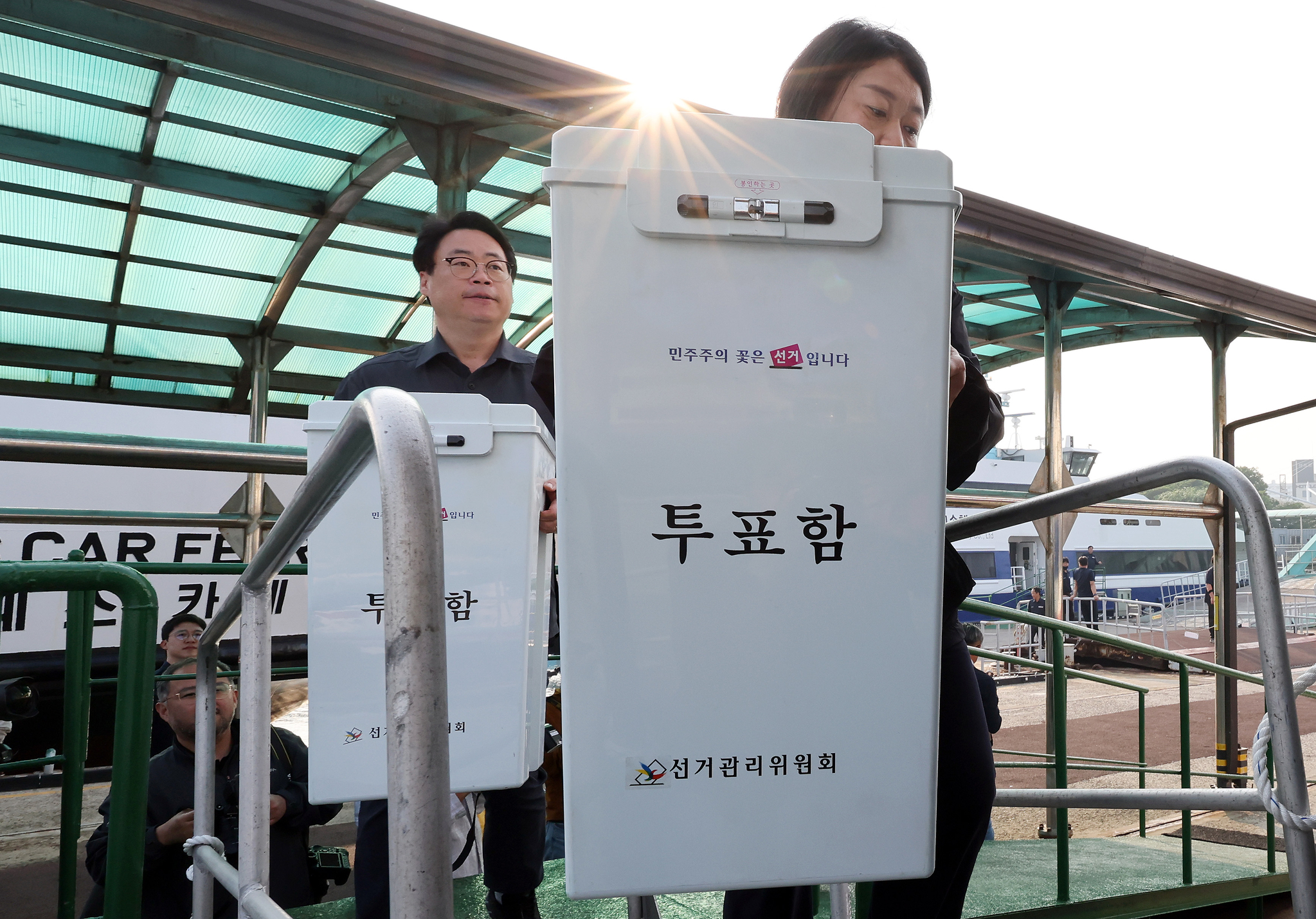 Local election workers at Incheon Port carry ballot boxes to a ferry that will transport the boxes to islands in the Yellow Sea on May 27. [NEWS1]