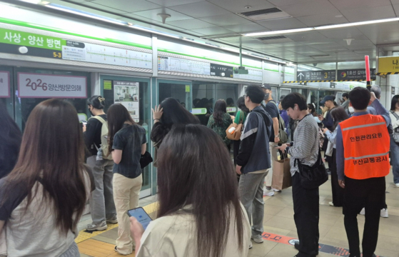 A Busan Transportation Corporation employee controls the crowd at Seomyeon Station, Busan’s busiest subway interchange, on May 28. [JOONGANG ILBO]