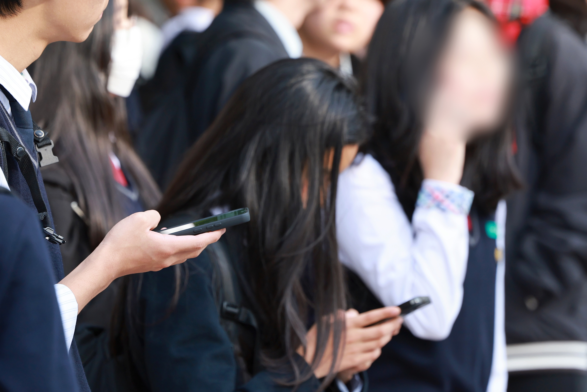 A student uses a smartphone after school at a middle school in Seoul on Nov. 4, 2024. [YONHAP]