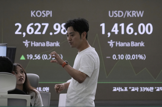 Currency traders work near a screen showing the Korea Composite Stock Price Index, left, and the foreign exchange rate between U.S. dollar and Korean won at the foreign exchange dealing room of the KEB Hana Bank headquarters in central Seoul on May 14. [AP/YONHAP]