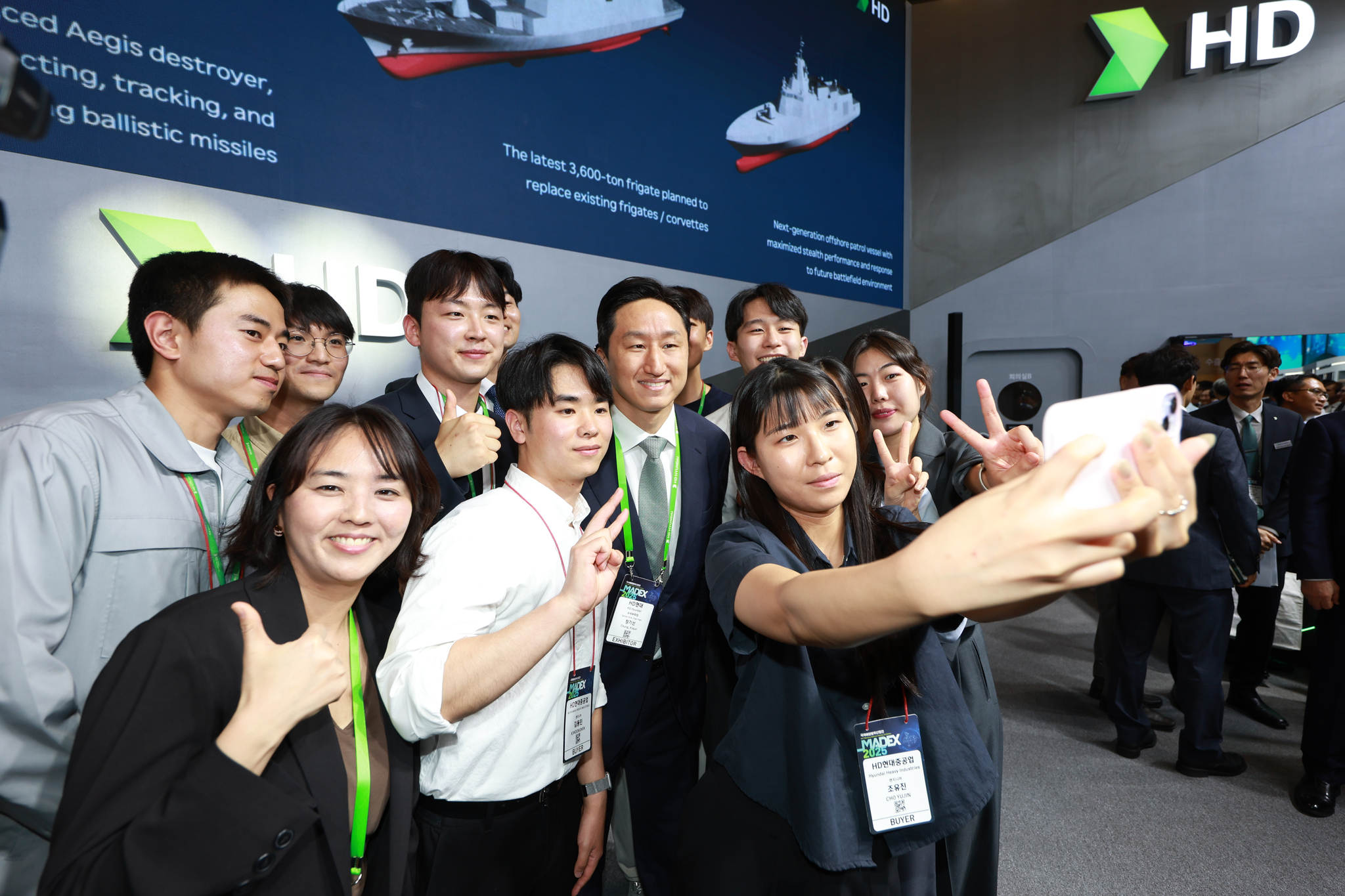HD Hyundai Executive Vice Chairman Chung Ki-sun, in the middle, poses for a selfie with his employees at Madex 2025, Korea’s largest maritime defense exhibition, hosted at Busan Bexco on May 28. [HD HYUNDAI]