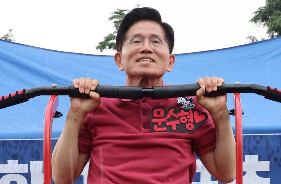 People Power Party presidential candidate Kim Moon-soo does a pull-up during a campaign visit to a university festival in Gyeongsan, North Gyeongsang, on May 28. [JOONGANG ILBO]