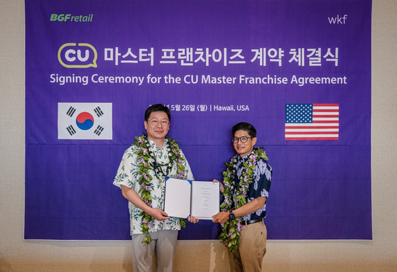 BGF Retail CEO Min Seung-bae, left, and CU Hawaii CEO Robert Kurisu pose for a photo with company representatives after signing a master franchise agreement for CU’s entry into the Hawaiian market on May 26. [BGF RETAIL]