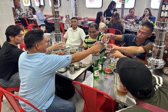 Filipino consumers enjoy Korean food while drinking Jinro soju in Manila on May 19. [HITEJINRO]