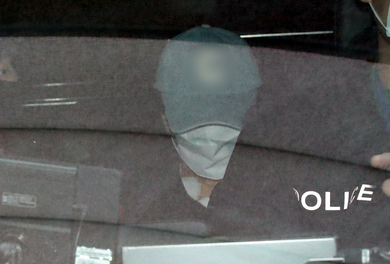 Myeong Jae-wan, the teacher accused of fatally stabbing a 7-year-old student at an elementary school in Daejeon in February, is seen in a police vehicle on March 7. [NEWS1]