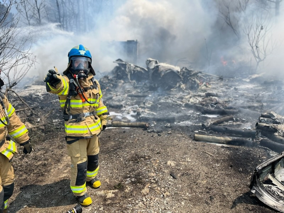 Firefighters conduct an extinguishing operation on a P-3C aircraft that crashed in Pohang on May 29. [NEWS1]