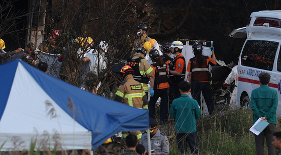Military personnel recover the bodies of the crew at the site of a Navy patrol aircraft crash in Sinjeong-ri, Donghae-myeon, southern Pohang, North Gyeongsang, on May 29. [YONHAP]    
