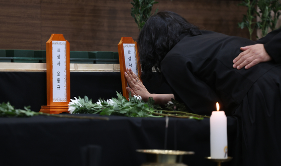 Grieving family members weep at the joint memorial altar for the victims of the Navy patrol aircraft crash, set up at the Navy Air Command gymnasium in Pohang, North Gyeongsang, on May 30. [YONHAP]
