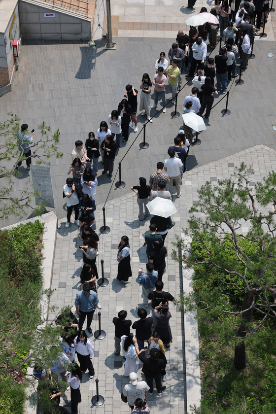 Voters wait in line to cast their ballots for the 21st presidential election during early voting period on May 30 in southern Seoul. [YONHAP]