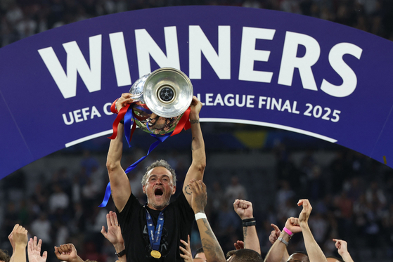 Paris Saint-Germain manager Luis Enrique lifts the Champions League trophy after winning the tournament at the Allianz Arena in Munich, Germany on May 31. [AFP/YONHAP] 