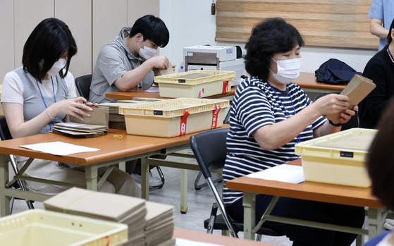 National Election Commission staff on May 31 check ballots cast during the presidential election's early voting period in Seoul. [NEWS1]