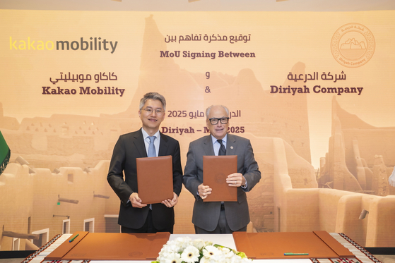 Kakao Mobility CEO, Ryu Geung-seon at left, and Diriyah Company CEO Jerry Inzerillo pose for photos after signing a memorandum of understanding in Saudi Arabia on May 25. [KAKAO MOBILITY]