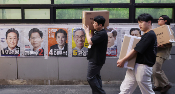 Public officials on May 30 move boxes filled with ballots cast during the presidential election's early voting period in Seoul. [YONHAP]