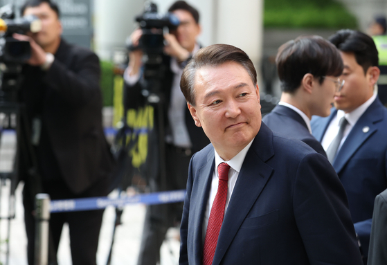 Former President Yoon Suk Yeol looks at his supporters as he appears at the Seoul Central District Court in southern Seoul on May 26 to attend the fifth hearing of a trial over insurrection charges in connection with his declaration of martial law. [JOINT PRESS CORPS]