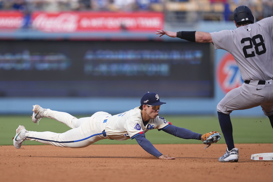 Los Angeles Dodgers second baseman Kim Hye-seong dives to force out New York Yankees' Austin Wells at second after Kim catches a ball hit by Jorbit Vivas that caught Wells off base during the third inning of an MLB game in Los Angeles on May 31. [AP/YONHAP]