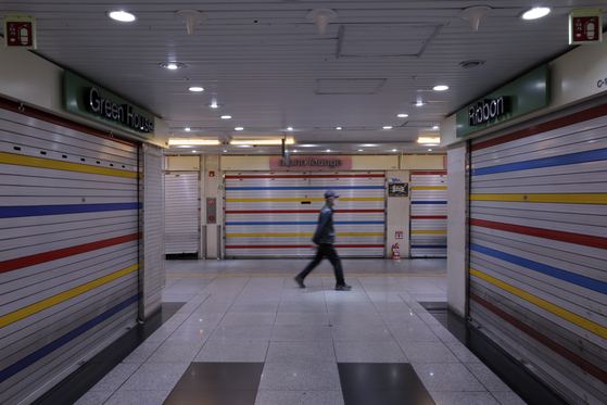 As projections indicated that the number of self-employed businesses closing this year would exceed 1 million, a passerby walks past shuttered stores in the underground shopping arcade at Jonggak Station in Jongno District, central Seoul. According to Korea Credit Bureau’s latest report on small businesses, a total of 3.619 million businesses received private business loans as of the first quarter, and 13.8 percent of those were found to be closed. [NEWS1] 