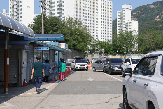 A polling station set up at the driver’s license test center in Uijeongbu, Gyeonggi, bustles with voters and vehicles on the morning of June 3, the day of the 21st presidential election. [YONHAP]