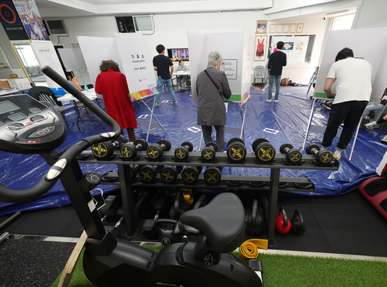 Voters cast their ballots at a polling station set up inside the Wrestling No.1 Multi-Gym in Namcheon-dong, Suyeong District, Busan, on June 3, the day of the 21st presidential election. [YONHAP]