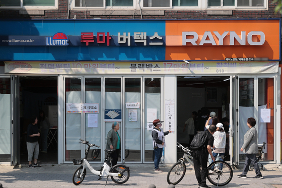 Voters cast their ballots at Namgajwa 2-dong No. 2 polling station located inside the Lumar Vertex window tinting shop in Seodaemun District, western Seoul, on June 3. [YONHAP]