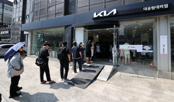 Voters wait in line to cast their ballots at a polling station set up inside the Kia Motors Daegongwon dealership in Gwangjin District, eastern Seoul, on June 3, the day of the 21st presidential election. [NEWS1]