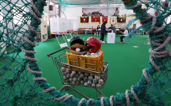 Voters cast their ballots at a polling station set up inside the indoor training facility of the baseball team at Cheonggu Elementary School in Jung District, central Seoul, on June 3, the day of the 21st presidential election. [NEWS1]