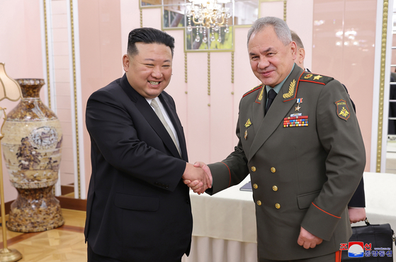 A photo released by Korean Central News Agency shows North Korean leader Kim Jong-un, left, shaking hands with Russian Security Council Secretary Sergei Shoigu, during a meeting at the office building of the Party Central Committee in Pyongyang, North Korea, on July 26, 2023. [EPA/YONHAP]