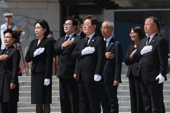 President Lee Jae-myung, center, and first lady Kim Hye-kyung, second to left, salute the national flag after paying their respects at Seoul National Cemetery in Dongjak District, southern Seoul, alongside the Democratic Party’s campaign leadership on June 4. [JOINT PRESS CORPS]