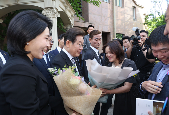 President Lee Jae-myung, second to left, and first lady Kim Hye-kyung, left, greet their supporters in front of their home in Gyeyang District, Incheon, on June 4. [JOINT PRESS CORPS]
