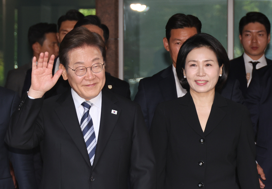 Newly elected President Lee Jae-myung, left, and his wife Kim Hye-kyung greet residents as they leave their residence in Gyeyang Destrict, Incheon on June 4. [JOINT PRESS CORPS]
