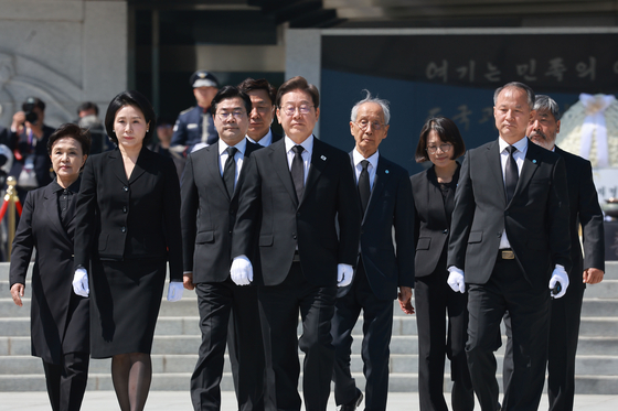 President Lee Jae-myung, center, and first lady Kim Hye-kyung, second to left, walk after paying their respects at the Memorial Tower at Seoul National Cemetery in Dongjak District, southern Seoul, alongside the Democratic Party’s campaign leadership on June 4. [JOINT PRESS CORPS]