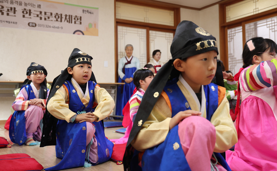 Children from multicultural families take part in a traditional New Year’s bowing ceremony during a special Seollal holiday class and experience program at the Yongin Etiquette Education Center in Yongin, Gyeonggi, on Jan. 22. [NEWS1]  