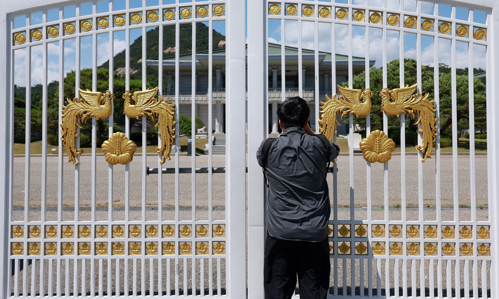 Visitors stand outside the Cheong Wa Dae, or the Blue House, gates in central Seoul, on June 4 afternoon. [YONHAP]
