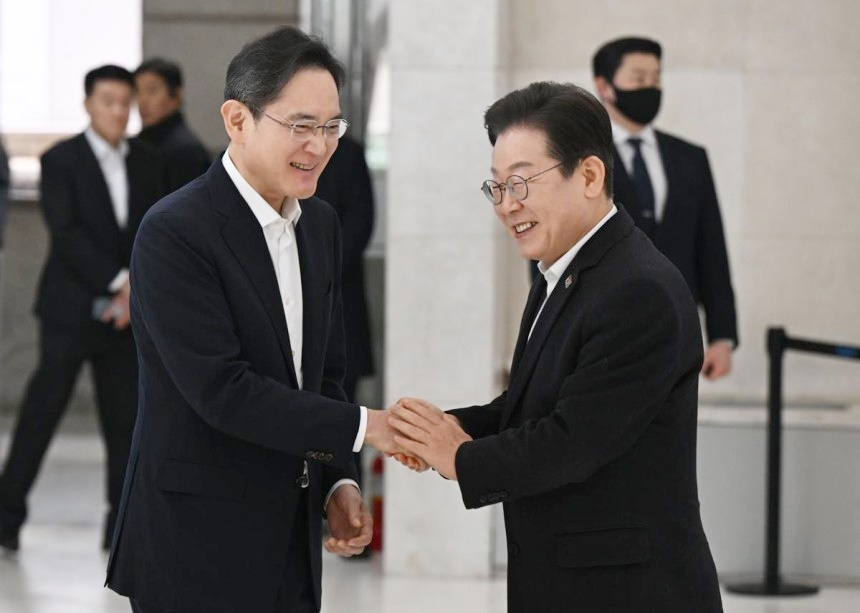 President Lee Jae-myung, right, greets Samsung Electronics Executive Chairman Lee Jae-yong, who welcomed him during a visit to the Samsung Software Academy for Youth in Gangnam District, southern Seoul, in March. [NEWS1]