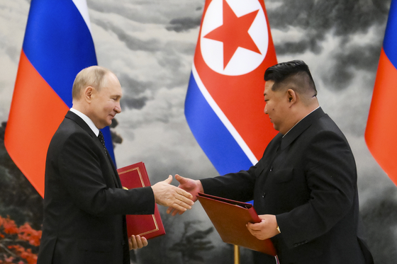 Russian President Vladimir Putin, left, and North Korean leader Kim Jong-un exchange documents during a signing ceremony of the new partnership in Pyongyang, North Korea, on June 19, 2024. [AP/YONHAP]