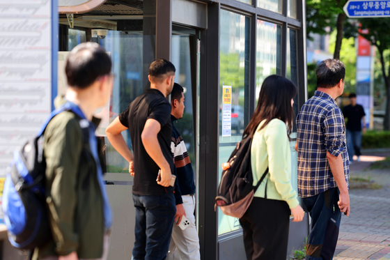 Commuters wait at a bus stop in Chipyeong-dong, Seo District, Gwangju, on June 5 as the city’s bus union launches a general strike. [YONHAP]