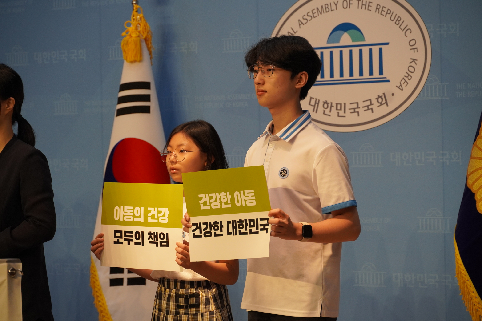 Children hold signs at a National Assembly press conference calling for stronger guarantees of their right to health in 2024. [GOOD NEIGHBORS]