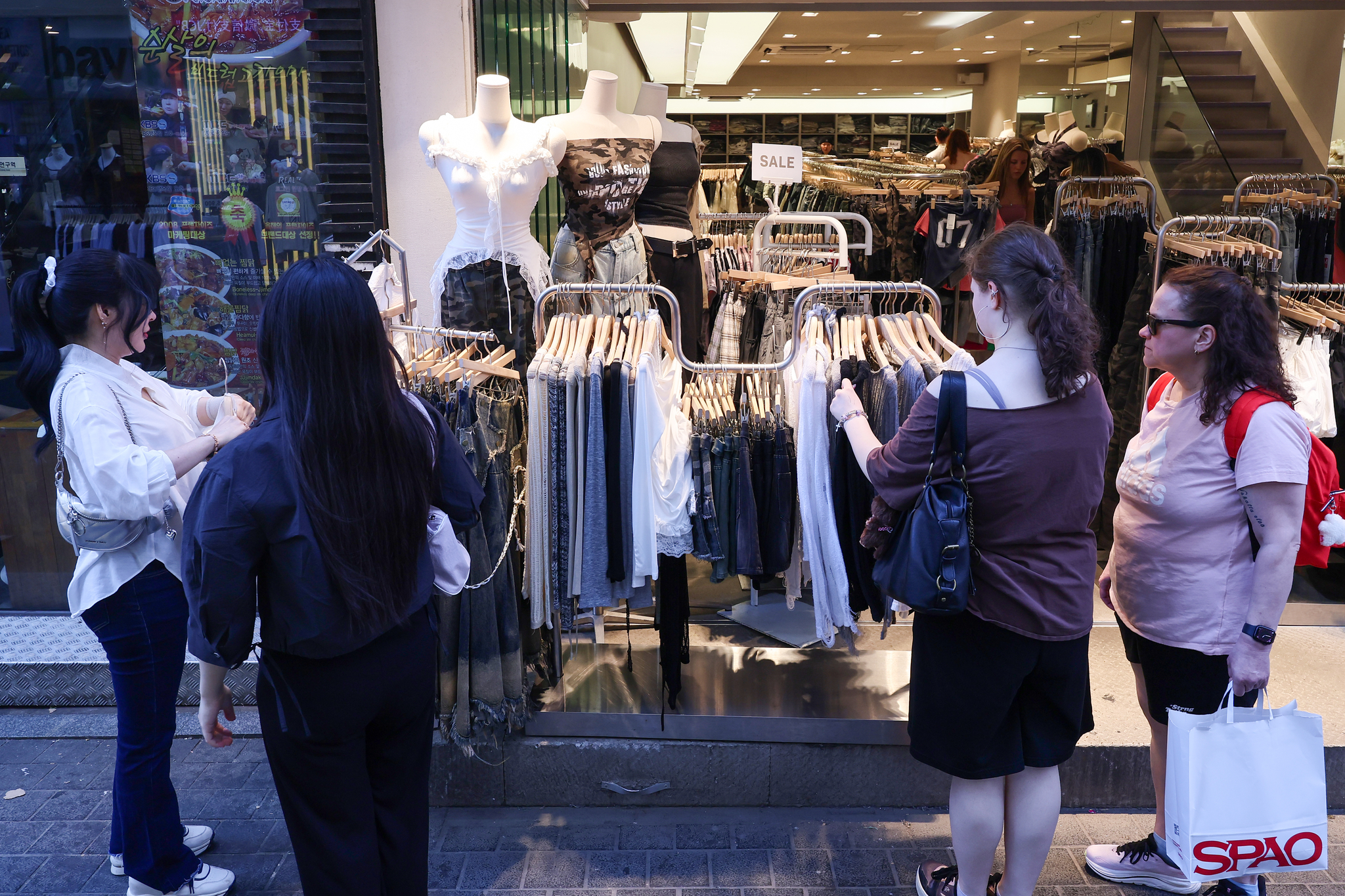 Passersby browse clothes at a store in Myeong-dong, central Seoul, on June 4. [YONHAP]