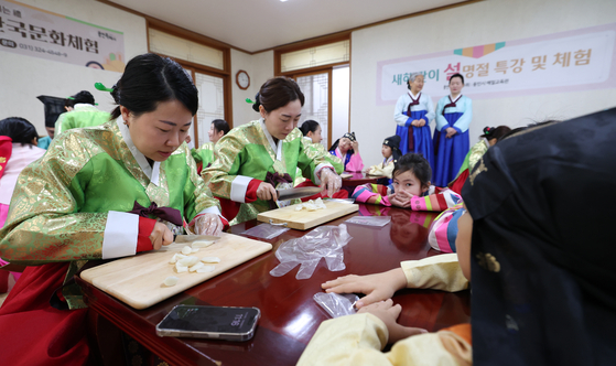 Participants from multicultural families make rice cake soup, during a special Lunar New Year class and hands-on program at the Yongin Etiquette Education Center in Yongin, Gyeonggi on Jan. 22. [NEWS1]