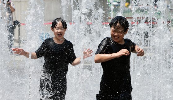 Children cool off at the fountain at Gwanghwamun Square in Jongno District, central Seoul, on June 6, amid early summer weather. [NEWS1]