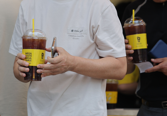 People buy iced coffee at a cafe in Yeouido, western Seoul on June 9. [YONHAP] 