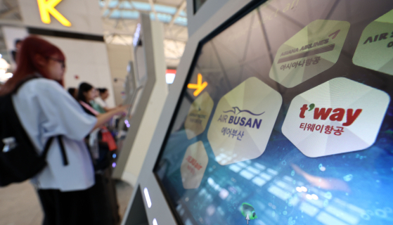 Travelers use the self-check in kiosks for low-cost carriers at Incheon International Airport's Terminal 1 on June 8, 2024. [YONHAP] 