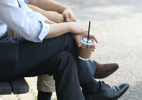 Office workers drink iced coffee at a park in downtown Seoul on Sept. 10, 2020. [YONHAP] 