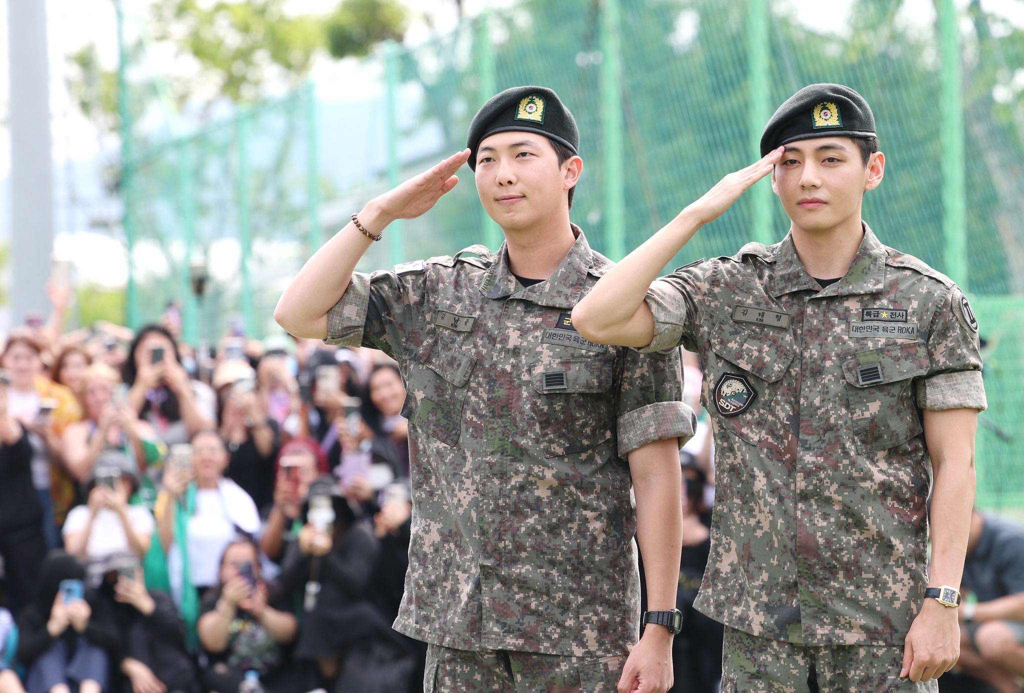 Members RM, left, and V of boy band BTS salute to fans after finishing their military duties on June 10 in Gangwon. [NEWS1]