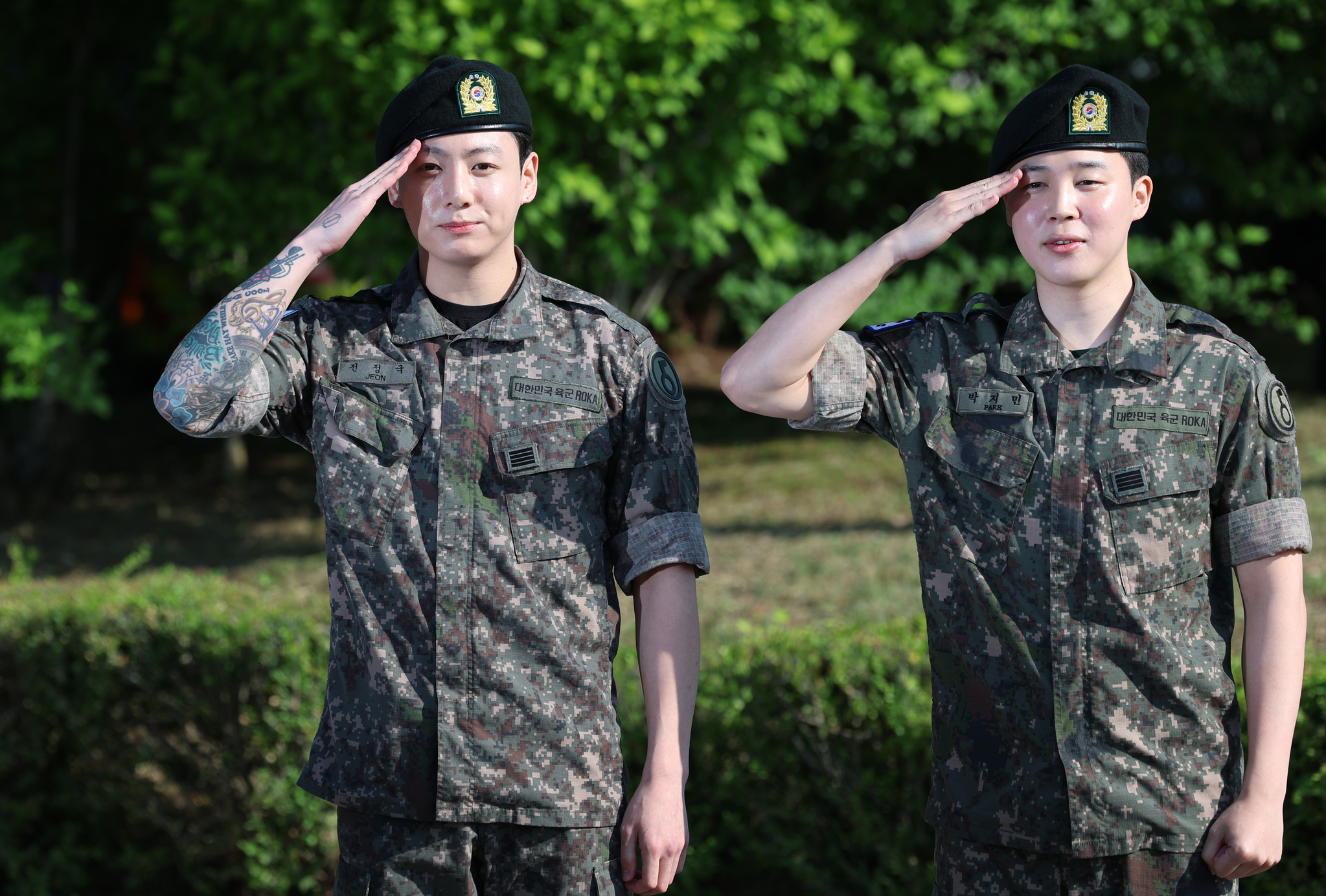 Members Jungkook, left, and Jimin of boy band BTS salute to fans after finishing their military duties on June 11 in Yeoncheon, Gyeonggi. [NEWS1]