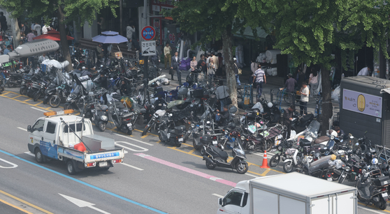 Motorcyles are tightly parked in front of a traditional market in Seoul on May 19. The license plate is stuck at the rear end of the vehicle. [YONHAP]