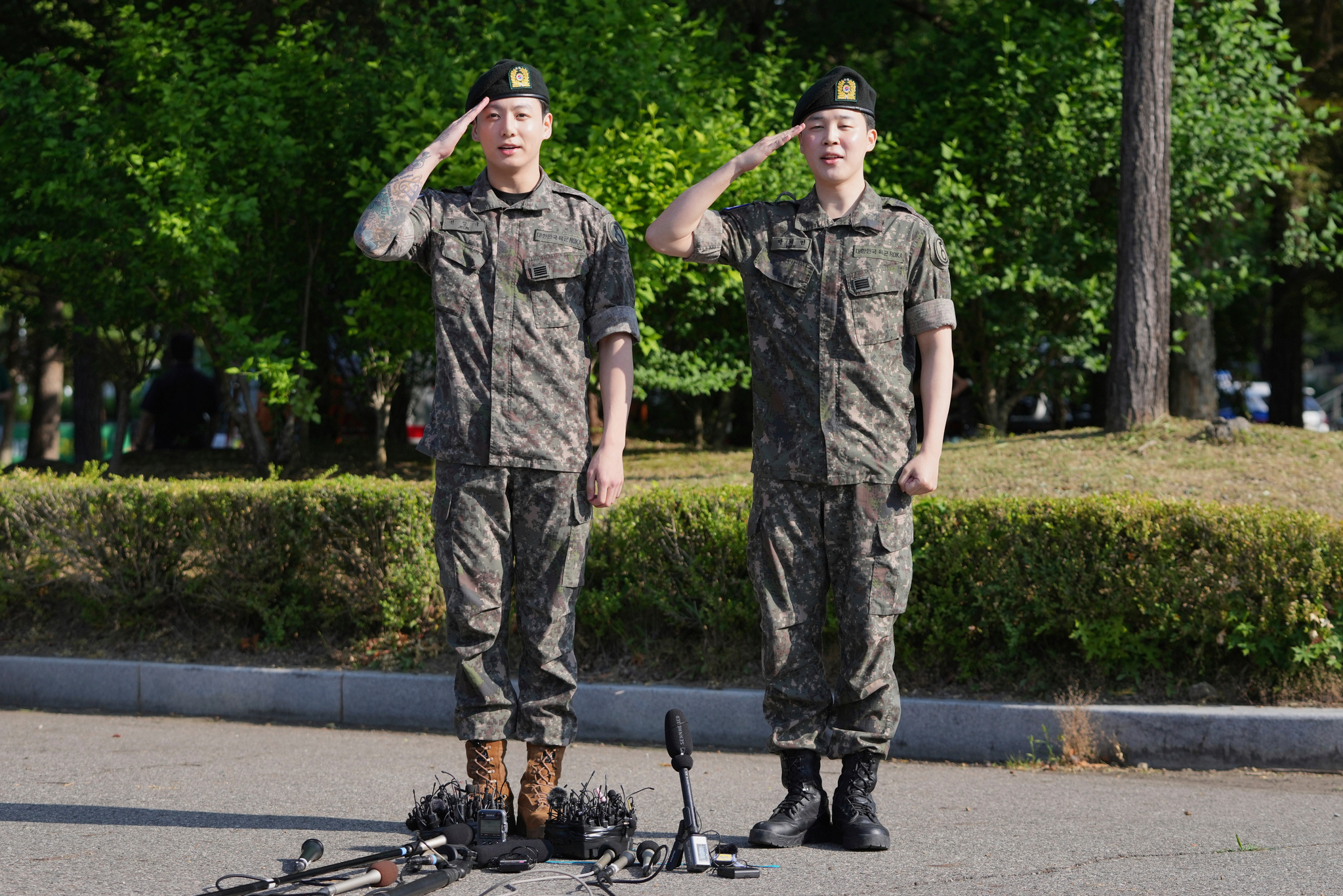 K-pop band BTS members Jimin, right, and Jungkook salute after being discharged from a mandatory military service in Yeoncheon, Gyeonggi, on June 11, 2025. [AP/YONHAP]