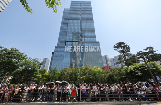 BTS fans, dubbed ARMY, cheer in celebration of Jimin and Jungkook's discharge in front of their agency HYBE headquarters in central Seoul on June 11. [YONHAP]
