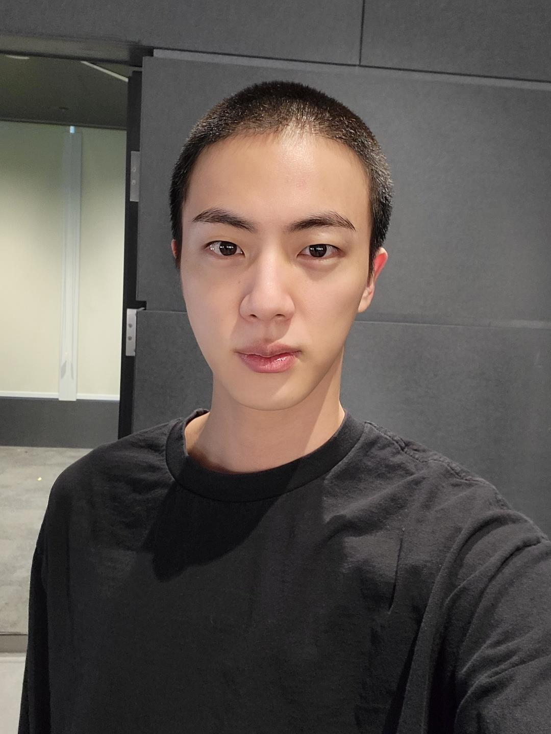 Jin poses for the camera after getting his hair shaved in preparation for military enlistment in a photo he uploaded on Weverse on Dec. 11, 2022, two days before he began his military service. [WEVERSE]