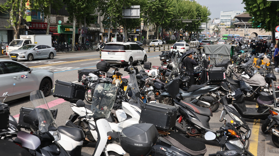 Motorcyles are tightly parked in front of a traditional market in Seoul on May 19. The license plate is stuck at the rear end of the vehicle. [YONHAP]